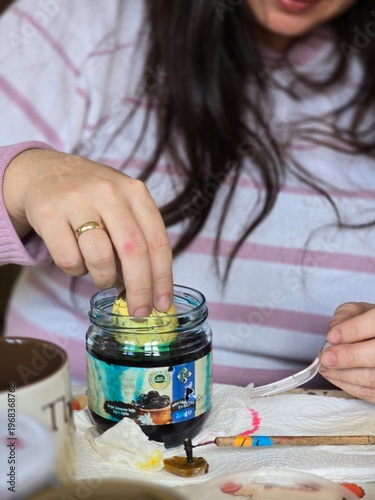 Young woman painting. The color of eggs for Easter.