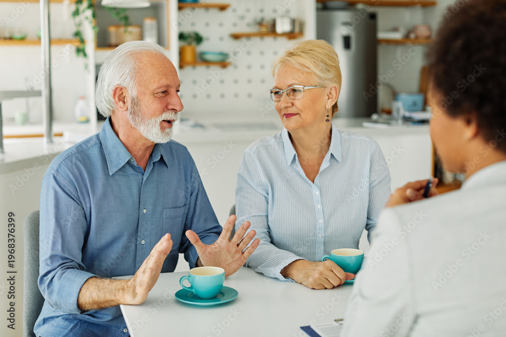 Obraz premium Senior couple having a meeting with an agent, businesswoman, salesperson or doctor in his office