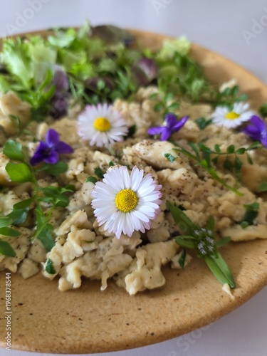 Healthy gourmet salad with edible flowers, daisies and fresh greens.