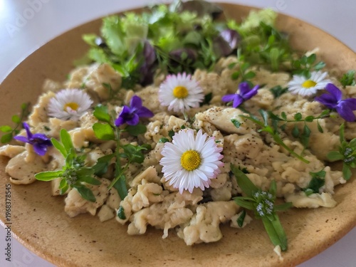 Healthy gourmet salad with edible flowers, daisies and fresh greens.