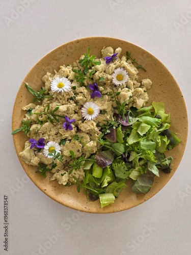Healthy gourmet salad with edible flowers, daisies and fresh greens.
