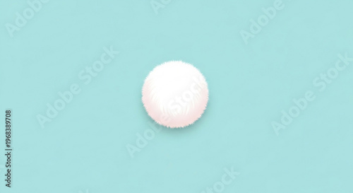A fluffy pale pink pom pom isolated on a light blue background