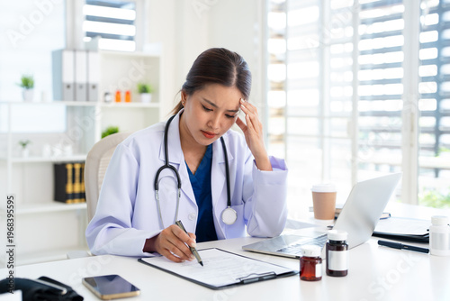 Overworked stressed female doctor nurse sit by computer with Frowning feel tired suffer from information overload pressure of responsibility worried of mistakes