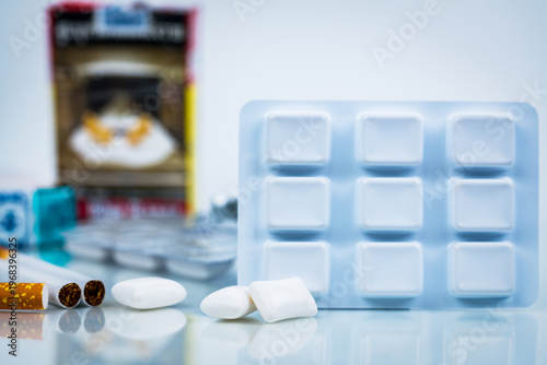 Foto Nicotine chewing gum and blurred cigarette pack, healthcare concept