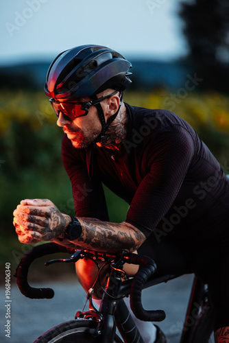 Cuadro en lienzo Male Cyclist Leaning On Aero Bars At Sunset With Tattoos And Glowing Tail Light