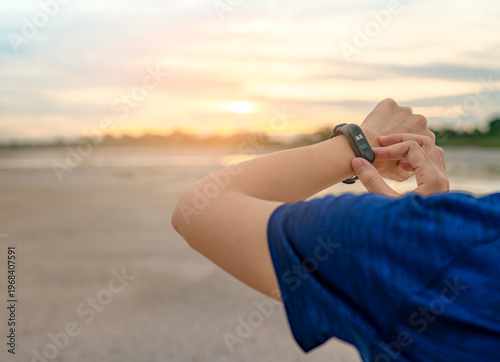 фотографія Woman touching smart fitness band after running, wearable device with heart rate monitor connected mobile app, healthy lifestyle