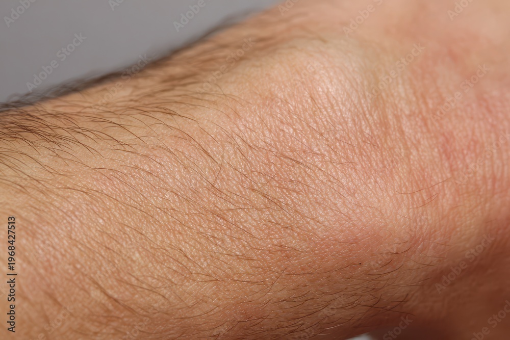 Fototapeta premium Close-up macro view of human skin texture with fine hairs and subtle wrinkles, detailed surface.