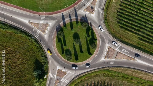 Aerial view of a modern roundabout in Veneto, showing traffic and transportation infrastructure surrounded by lush Italian vineyards and rural landscape in summer.