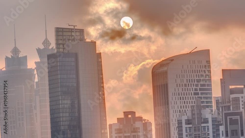 golden sunset over tall skyscrapers in the Dubai Business Bay district. Aerial view of downtown featuring colorful clouds in the sky during time-lapse.
