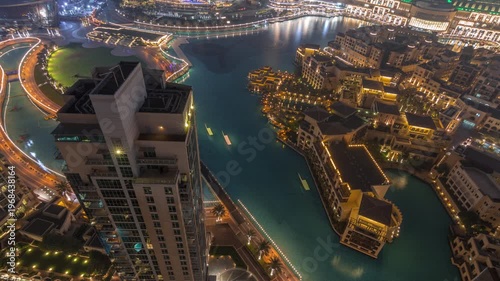 Traditional illuminated Old Town Island and fountains area near the mall and souk in Dubai Downtown. Aerial look down night view of architecture in time-lapse.