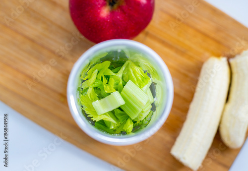 Green detox smoothie in the making. Apple, banana, celery, and a blender.