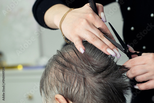Hairdresser Trimming Grey Hair Of Old Woman