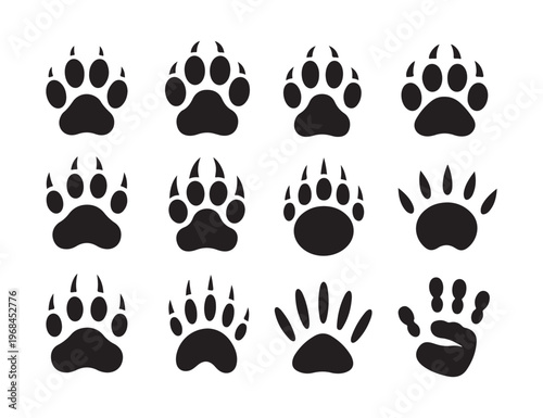 Twelve stylized black paw prints and one handprint arranged in a grid formation on white background isolated.