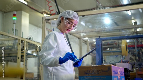 The production supervisor is inspecting and controlling the operation of packaging line of the canned fish processing plant