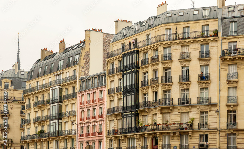 Fototapeta premium Haussmann architecture in Paris, typical street with classic apartment buildings and diverse balconies