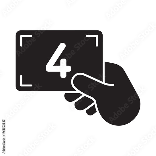A hand holding a card with the number four within a camera frame