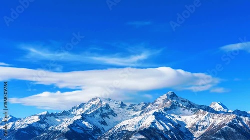  a mountain horizon with soft cloud drift under bright sky, seamless loop 