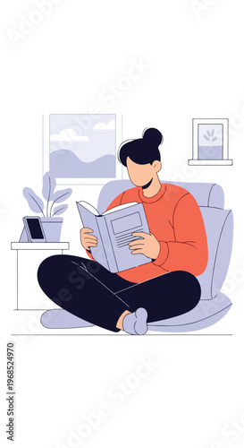 A person with dark hair sits in a comfy chair reading a book in a cozy room