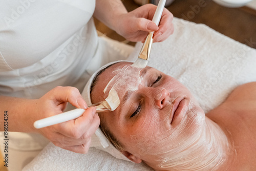 Bild auf Leinwand Woman receiving professional facial treatment with mask at spa