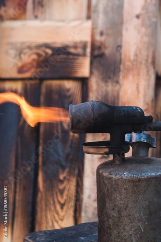 decorative burning of a wooden pallet for a street table with an old gasoline blowtorch