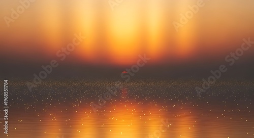 Sunset over a calm body of water with golden reflections and scattered light particles