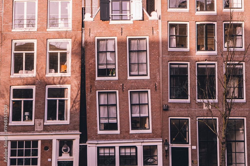 Fototapeta premium Traditional leaning brick houses with large windows in Amsterdam