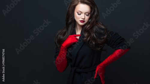 Elegant woman red gloves scarlet lips black coat