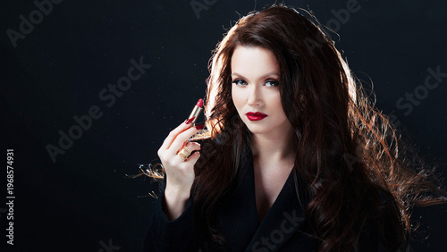 Glamorous brunette with red lipstick, dark background