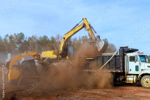 Heavy machinery removes dirt loads it into truck on construction site in rural area