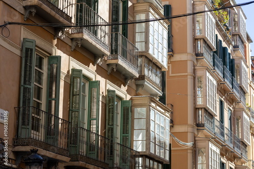 Charming balconies of Malaga reflecting the warmth of Spain's vibrant architecture in the afternoon sun