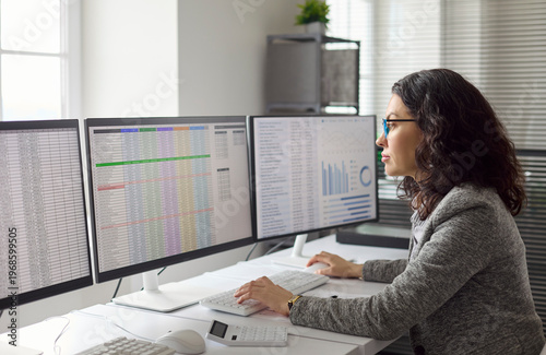 Obraz na płótnie Analyst woman performing data analysis at office computer