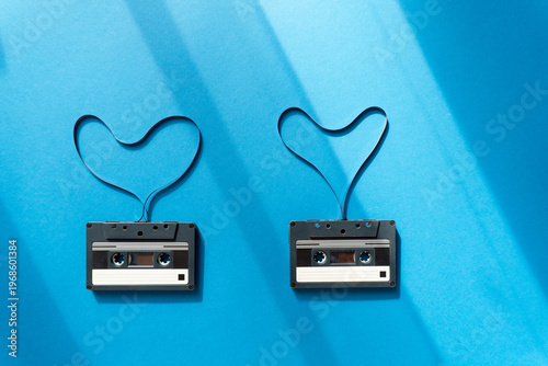 cassettes with magnetic tape in the shape of heart on blue background