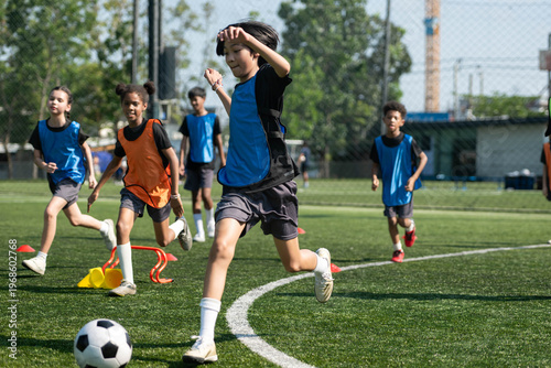 Tableau sur toile Group of international school kids playing soccer together on the field