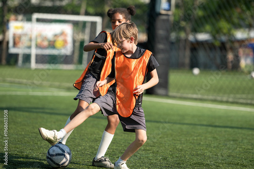 Group of international school kids playing soccer together on the field
