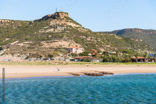 The coast of Bosa Marina, a charming seaside village located in Sardinia, Italy. Scenic Mediterranean coastline with sandy beach, colorful buildings, and clear blue sea.