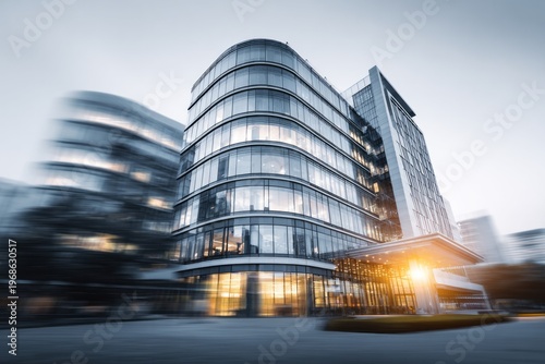 Modern architectural structure with curved glass facade reflects evening light