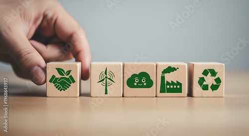 Hand arranging wooden blocks with green icons representing eco friendly practices and sustainable development