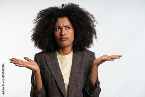 Φωτογραφία confident young businesswoman shrugging shoulders in office, doubtful profession