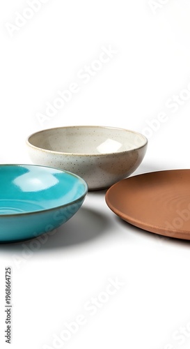 Three ceramic bowls of different colors on white background.