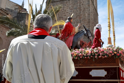 Liturgical figure watching La Borriquita float during Holy Week in Talavera de la Reina, Spain