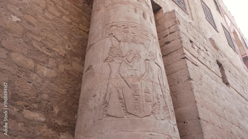 Close up view of an ancient stone column featuring intricate Egyptian hieroglyphs and carvings at the historic Luxor Temple in Egypt.