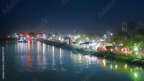 A scenic night view of a river cruise ship docked along the Nile River in Luxor, Egypt, with city lights reflecting on the water.
