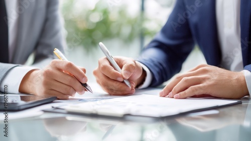 Business meeting in office with two people signing documents and taking notes at a table on a clear day