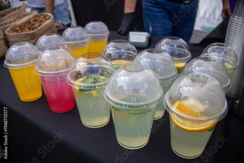 Colorful refreshing drinks in plastic cups on a market stall