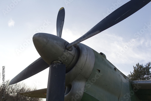 Close-up of a vintage military aircraft nose and propeller against the sky. Aviation and flight concept