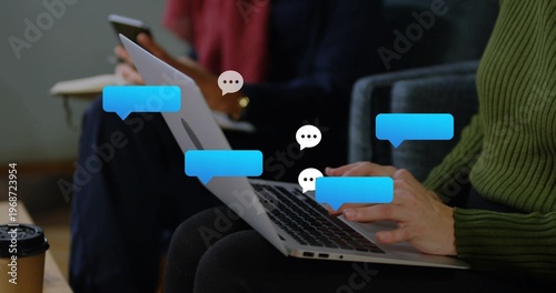 Typing woman in green sweater tapping silver laptop keys at lounge, chat bubbles floating