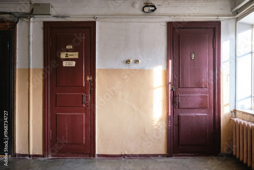 An old door with signs leading to a shower and toilet in a common corridor on the floor, Soviet Union. Old doors toilet and bathroom. Communal apartment.