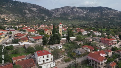 Village with terracotta roofs nestled at the base of a rugged mountain.