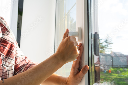 Tableau sur toile Home window opening with hand control on quality fitting, draft prevention, comfort regulation, installation and window business, improved acoustics