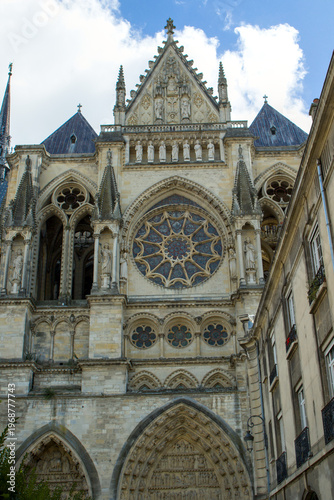 The sun illuminates the intricate stonework of this historical French masterpiece. Intricate rose windows and majestic stone statues define the facade of this cathedral.